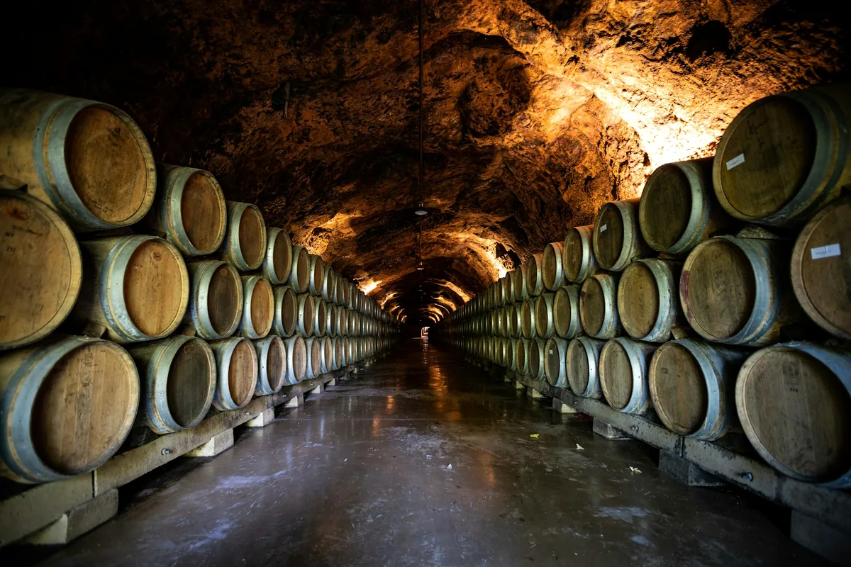 Barrels stacked along a tunnel cut through rock