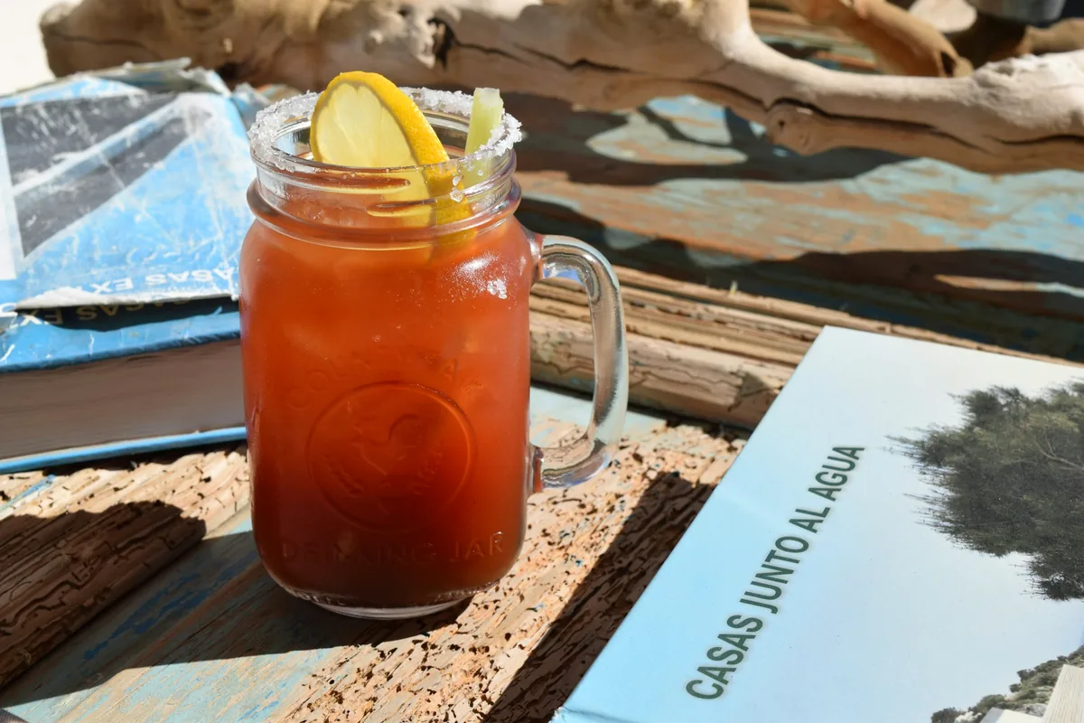 A Bloody Mary served in a glass jar with a lemon slice