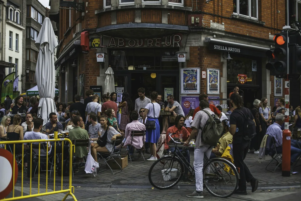 A busy street corner in central Brussels with cafes and passers-by