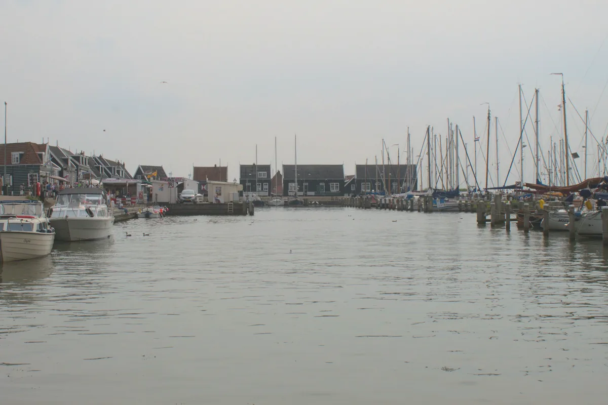 Fishing boats moored along a harbour under a grey sky