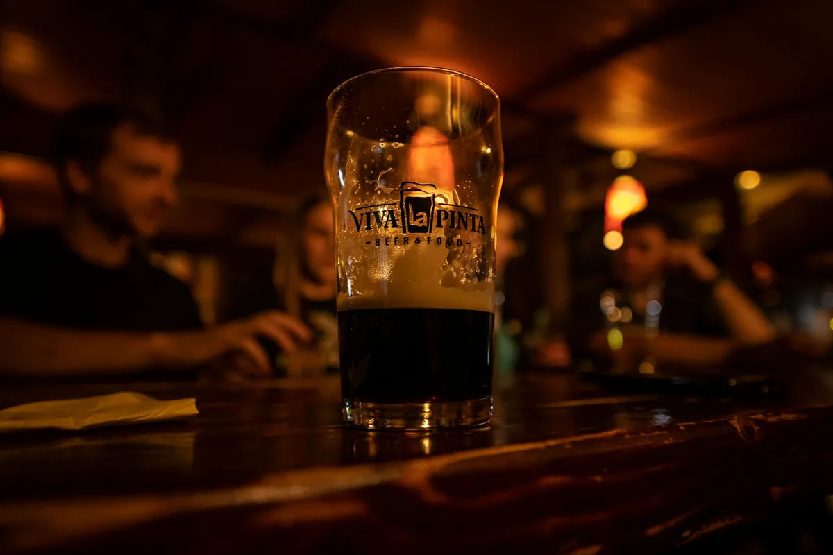 A glass of dark beer standing on a bar counter