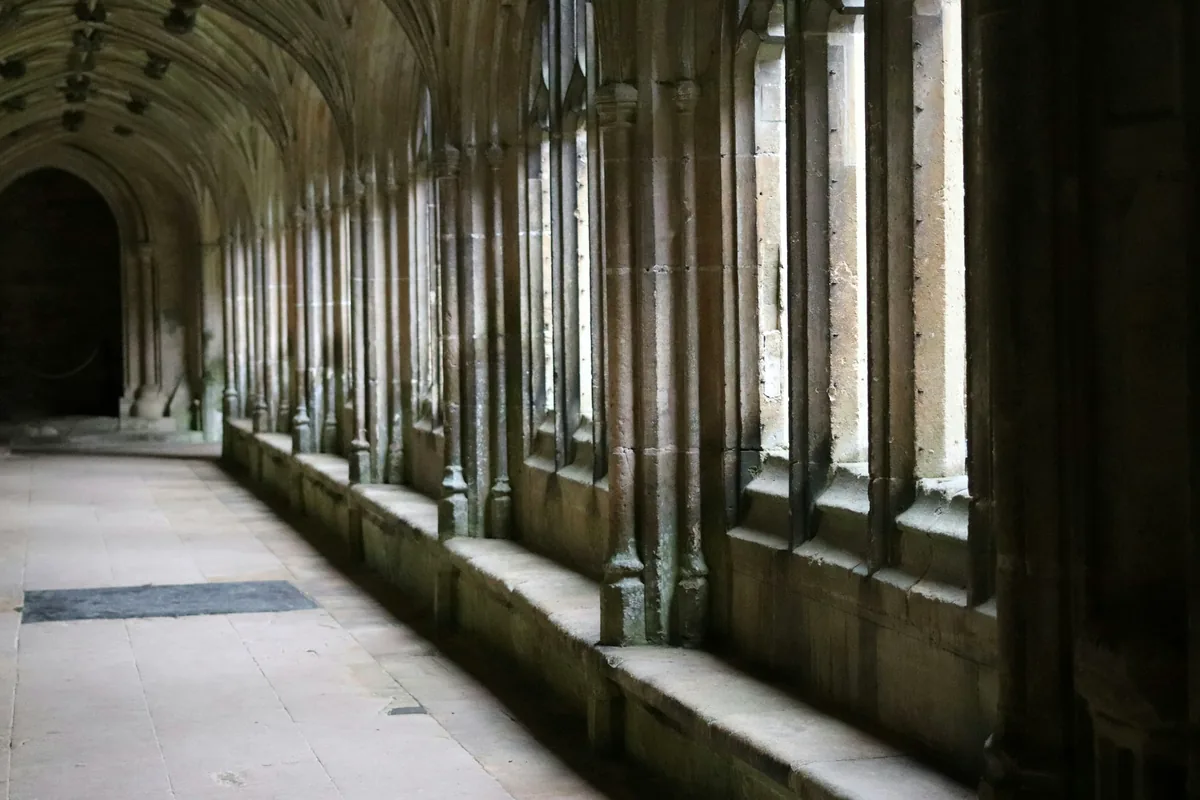 A long gallery of stone arches receding into the distance