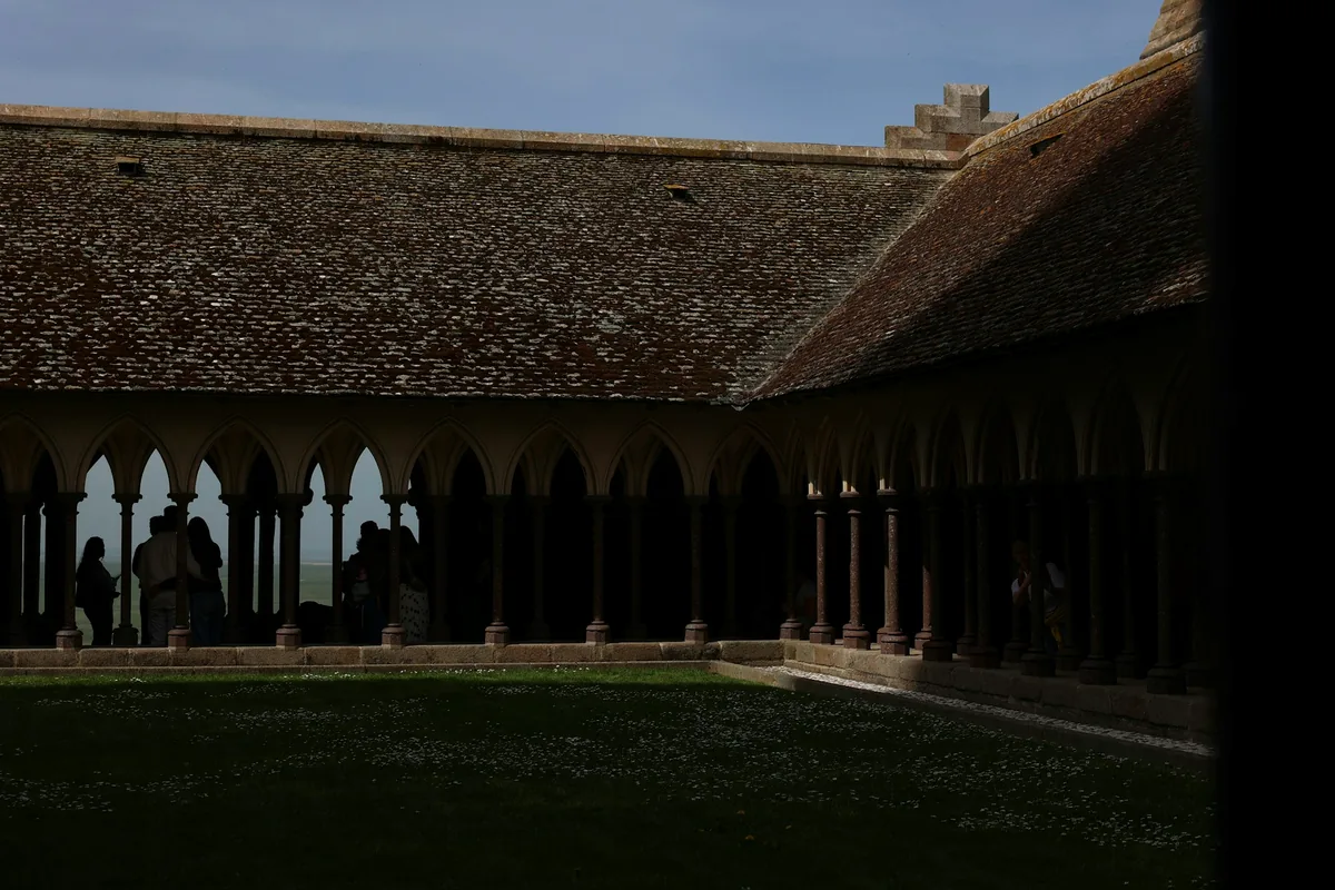 An arcaded courtyard with distant figures walking under the colonnade