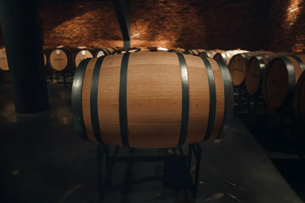 One hooped oak barrel resting on a stand under warm light