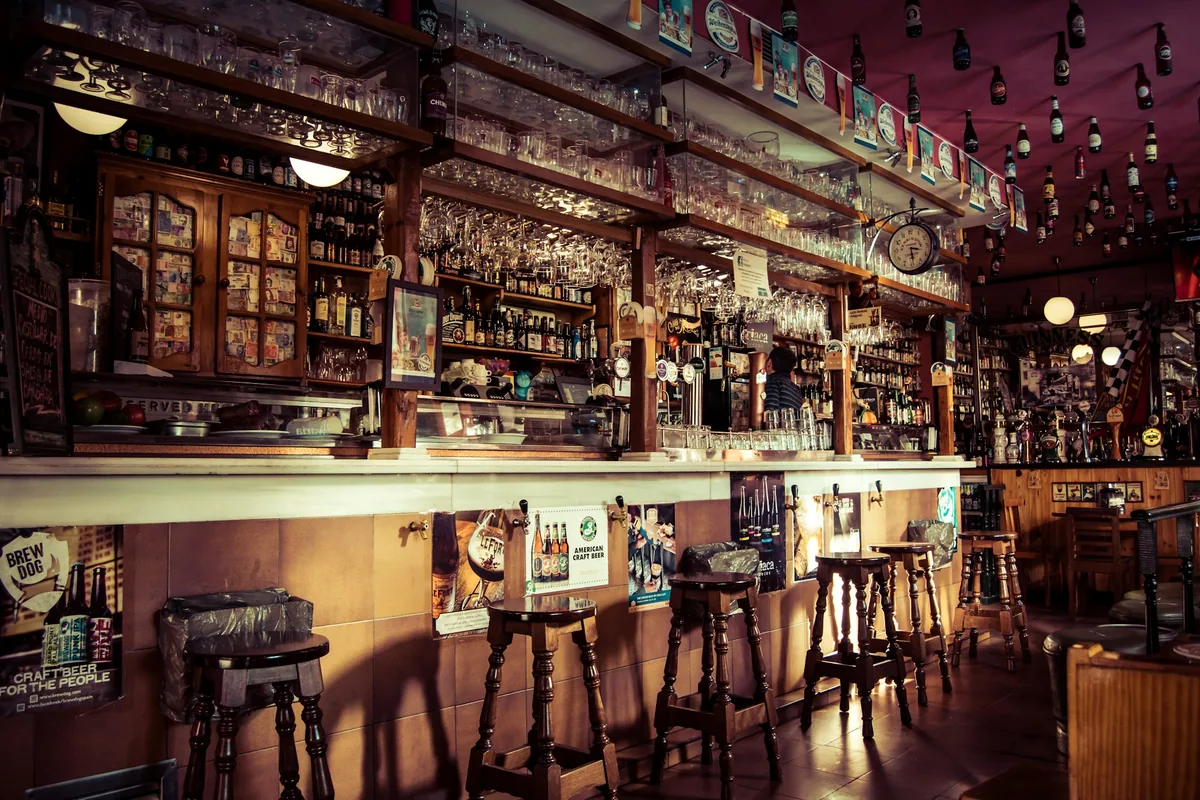 A small warmly lit bar in Madrid with bottles behind the counter