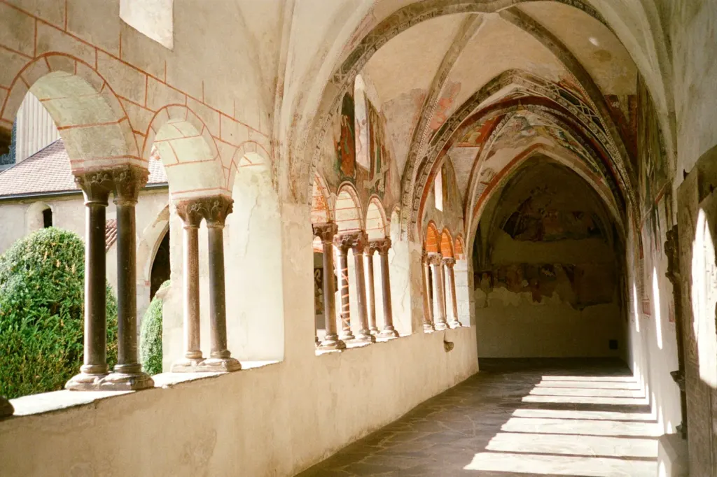 A stone cloister with arched columns and a vaulted ceiling