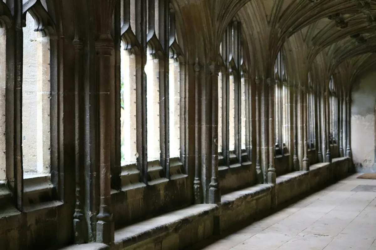 A row of arched stone windows along a monastic passage