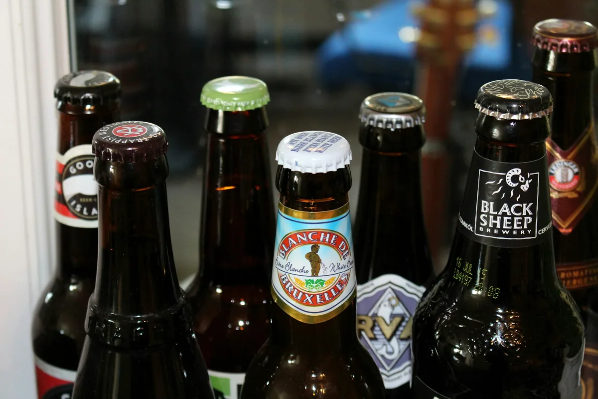 A group of beer bottles of different brands and colours