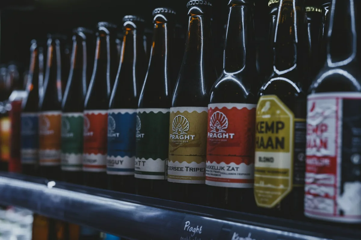 A long bar counter lined with beer bottles and tap handles