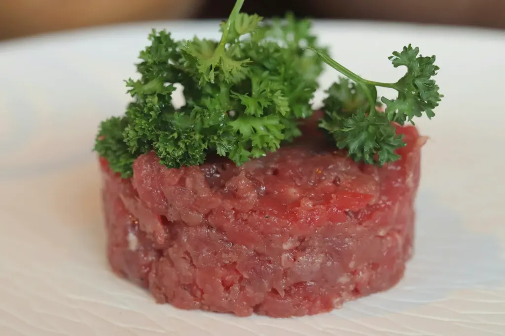A round moulded portion of raw beef tartare topped with parsley