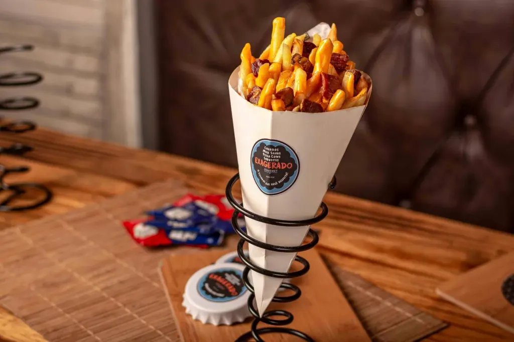 Thick-cut fries served upright in a paper cone in a wire holder