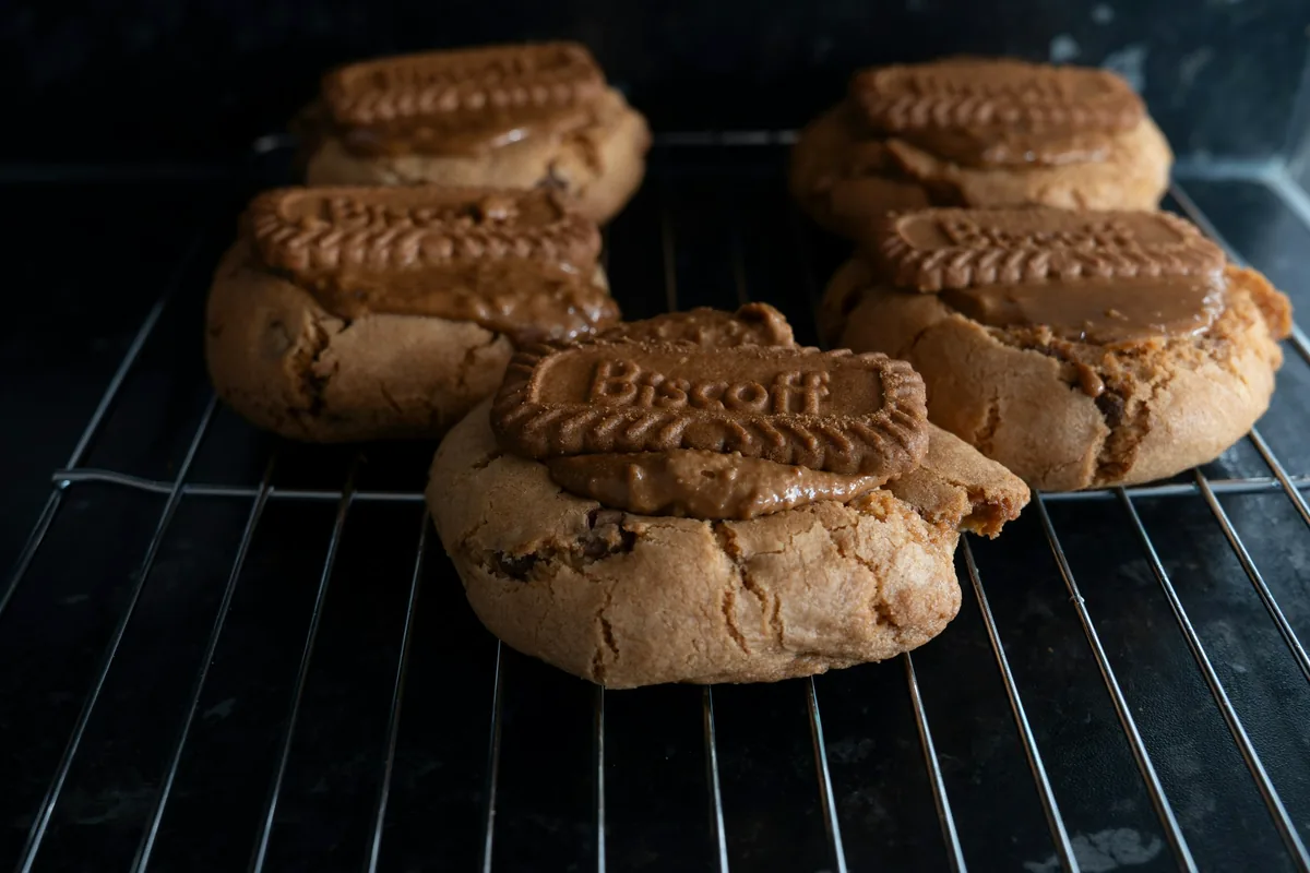 Cookies topped with Lotus Biscoff caramelised biscuits on a cooling rack