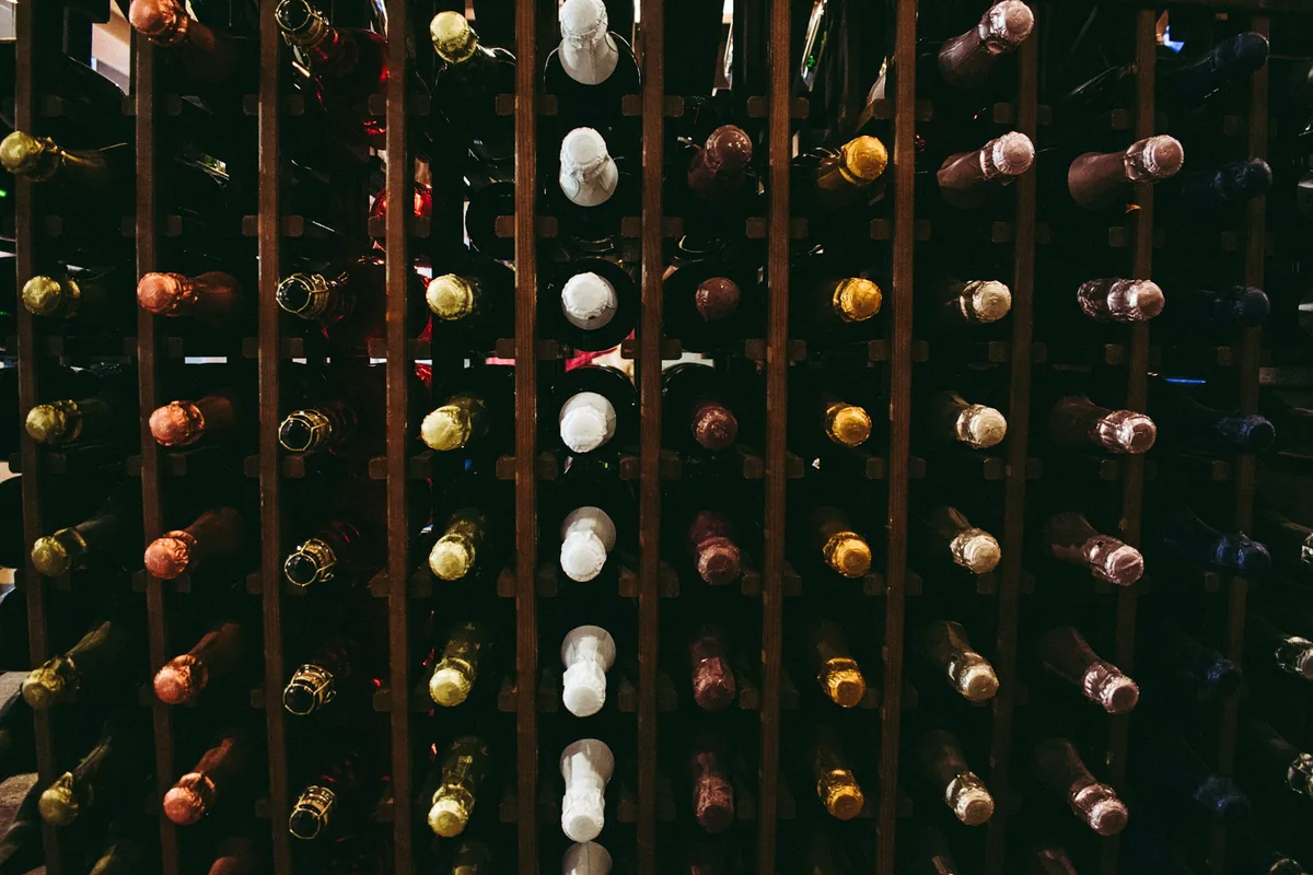 Sparkling wine bottles stored neck-down in wooden racks