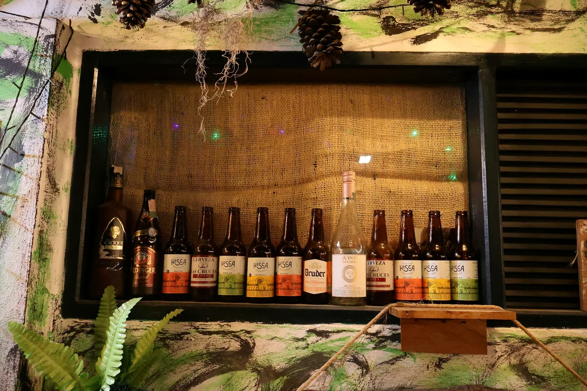 Assorted bottled drinks displayed on a rustic wooden shelf