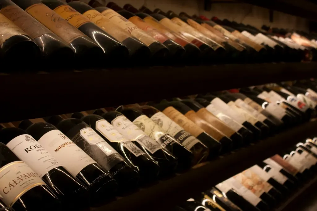 Rows of bottles lying on their sides in a dark cellar rack