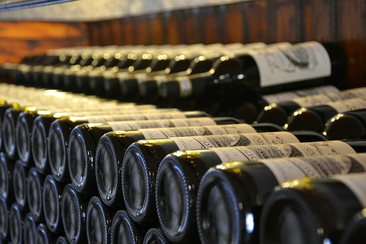 Bottles stacked horizontally in a dark storage rack