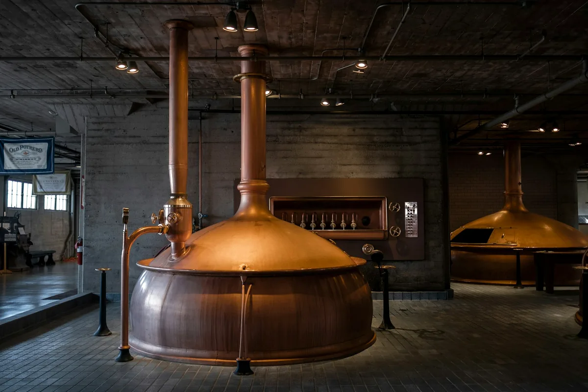 The interior of a brewery with large copper vessels