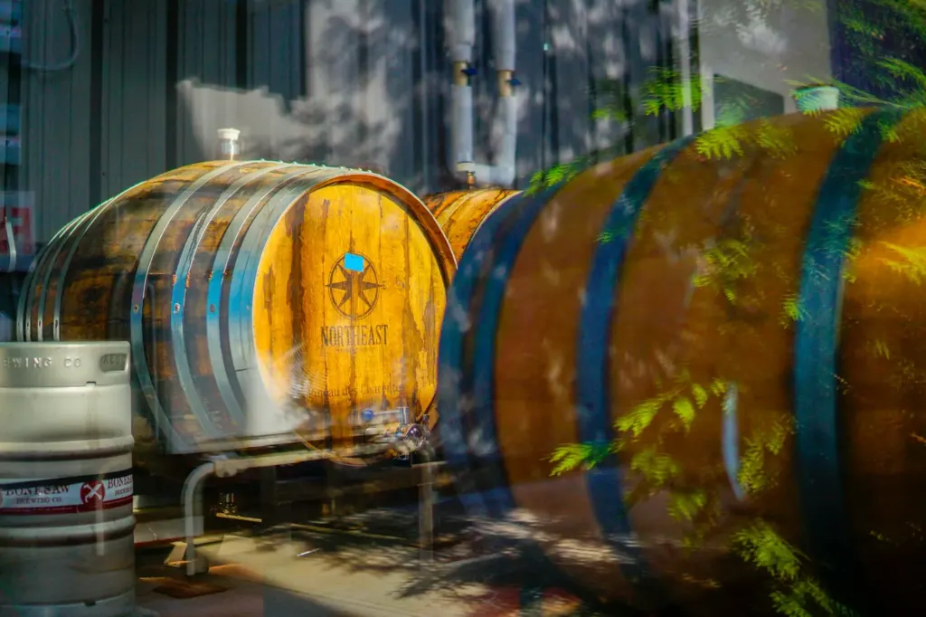 Large wooden barrels lying on their sides at a brewery