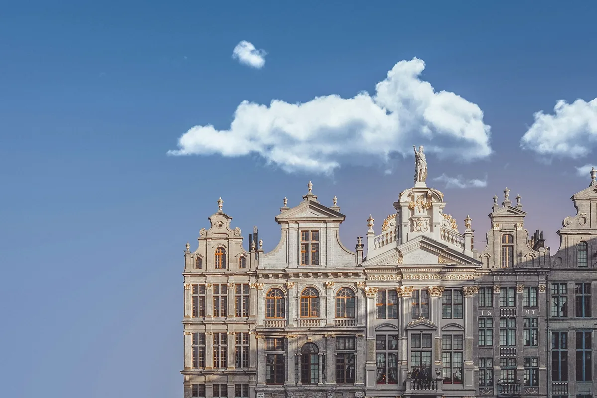 An ornate gilded guildhall facade in Brussels against a blue sky