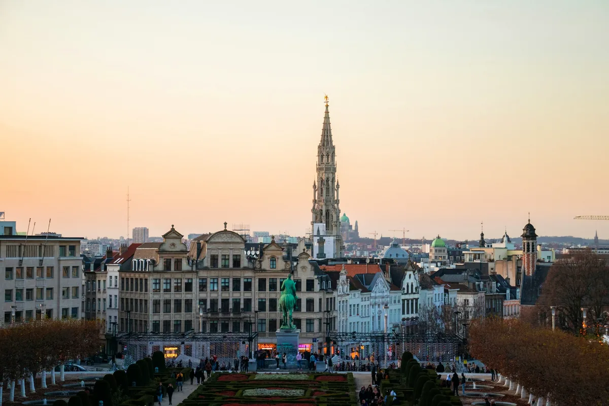 The Brussels skyline at dusk with the town hall spire above the rooftops