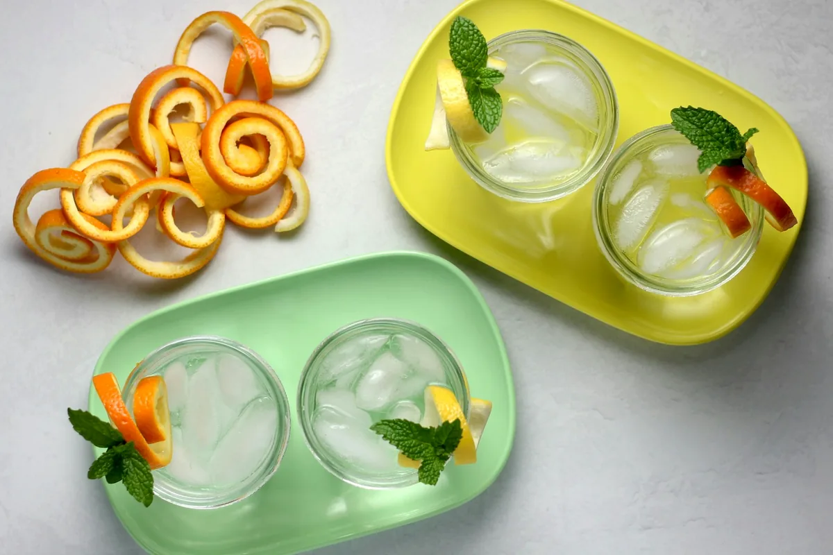 Curls of citrus peel beside prepared drinks on trays