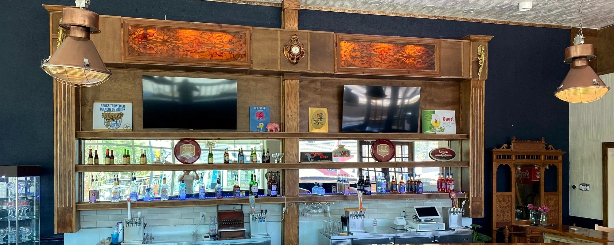 The Meyboom back bar, its shelves lined with bottles beneath the carved wooden gantry and copper lamps
