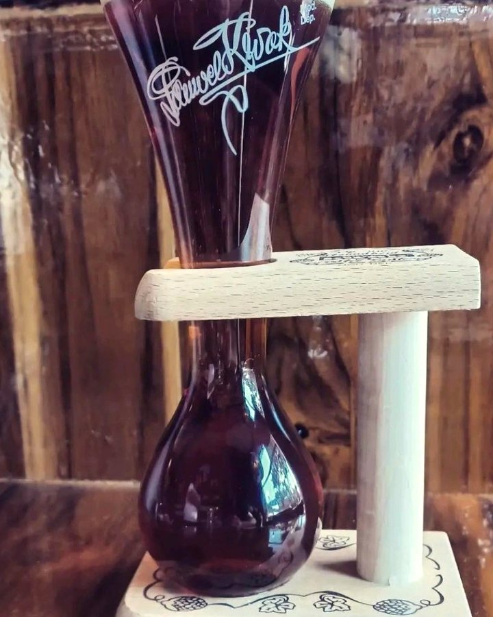 A Kwak beer in its rounded glass, held upright in a turned wooden stand