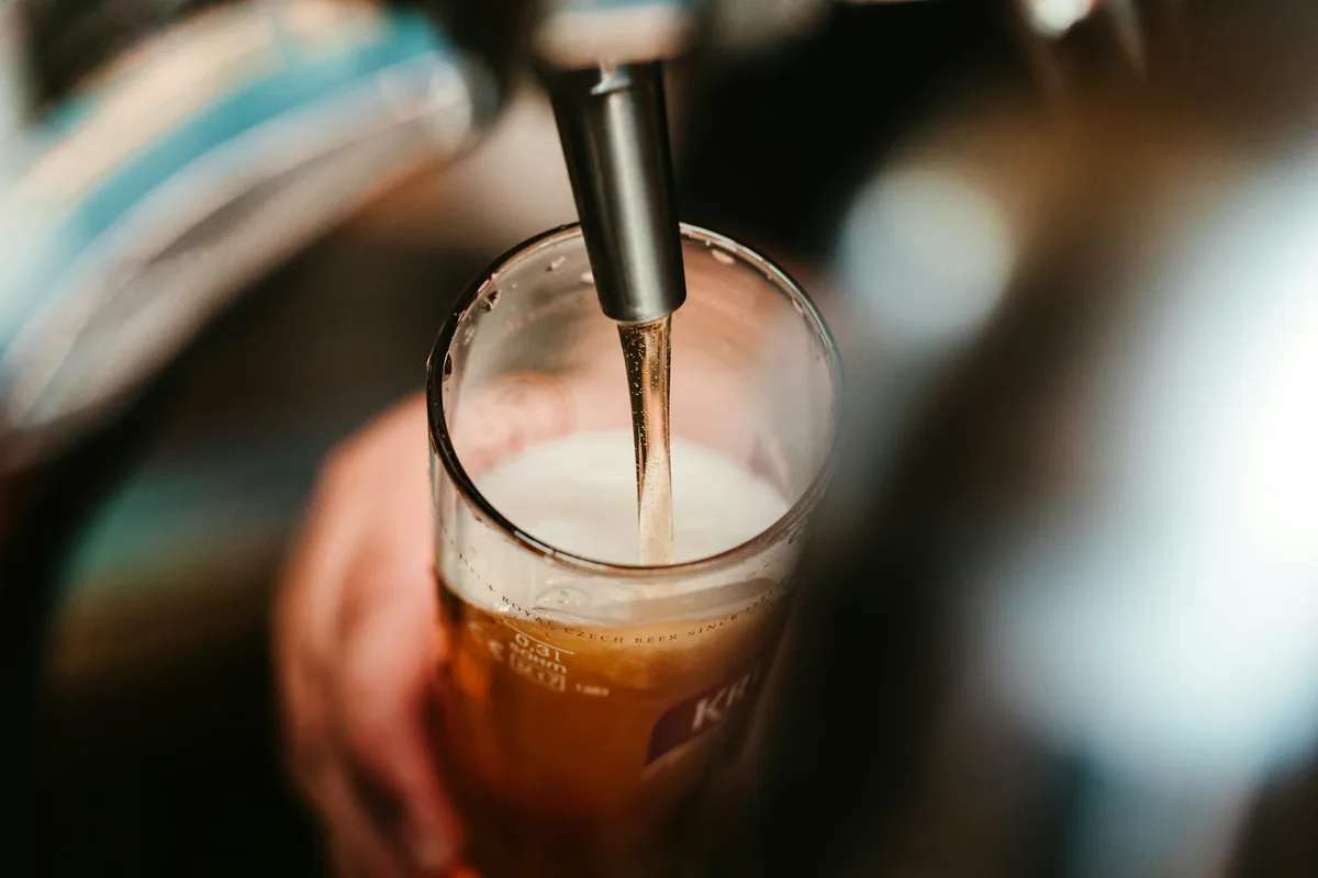 A glass being filled with beer from a tap