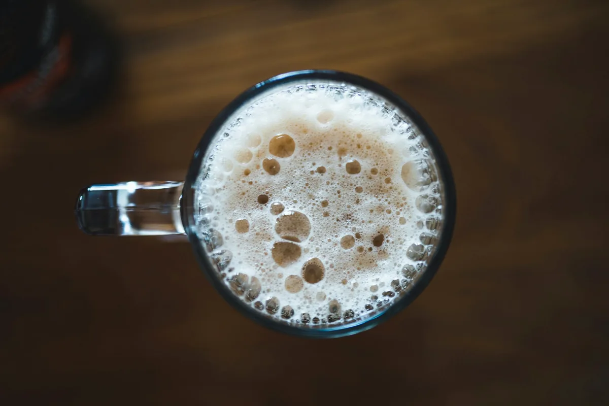 A beer mug photographed from directly above showing its foam surface