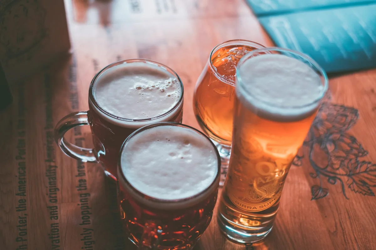 Four glasses of beer on a table running from dark brown to pale gold