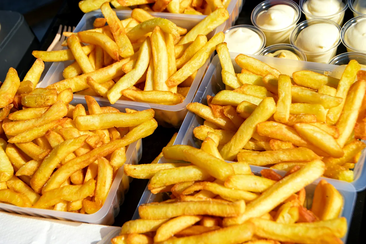 Trays of golden fries beside small pots of sauce