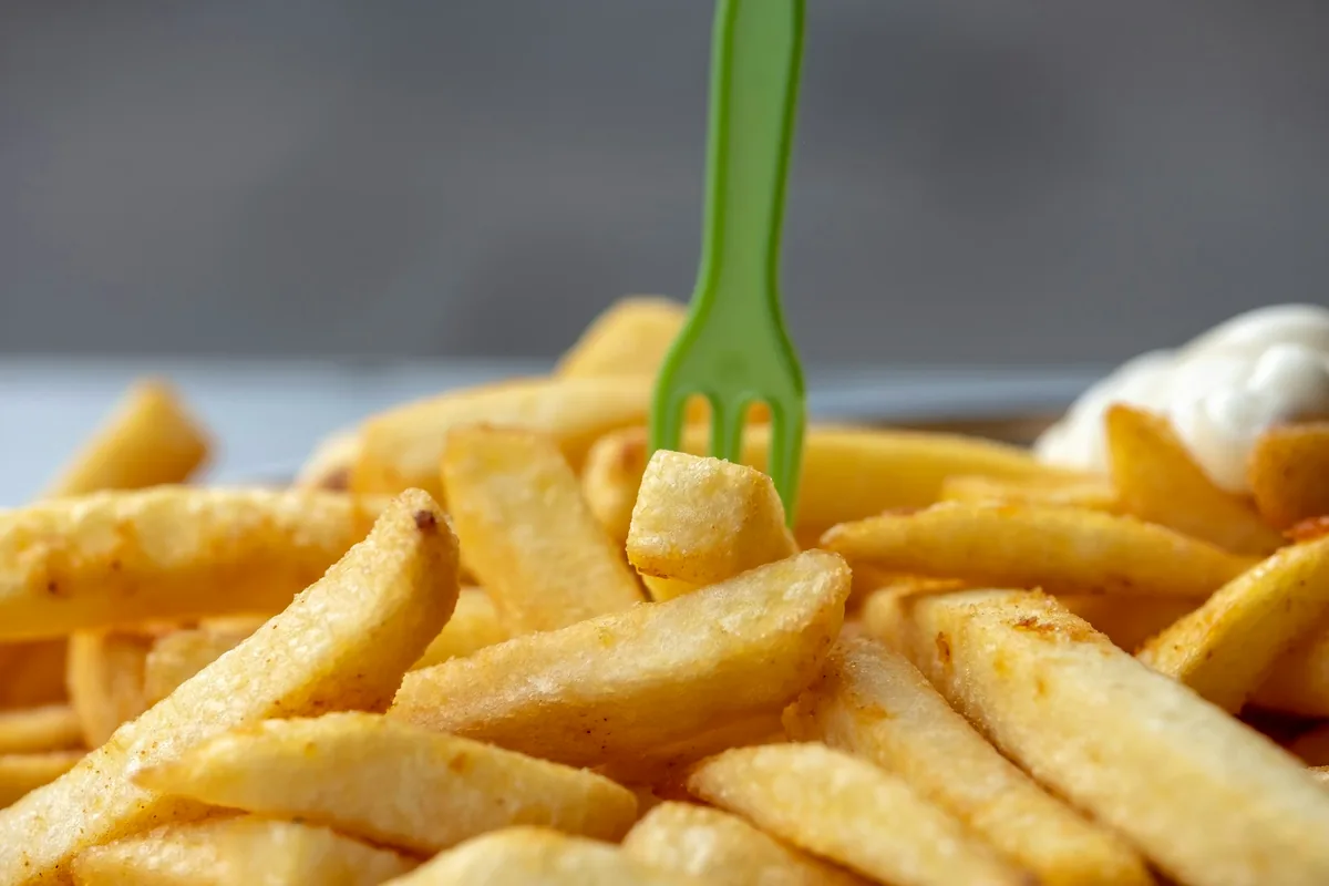 Fries in a paper container with a small plastic fork