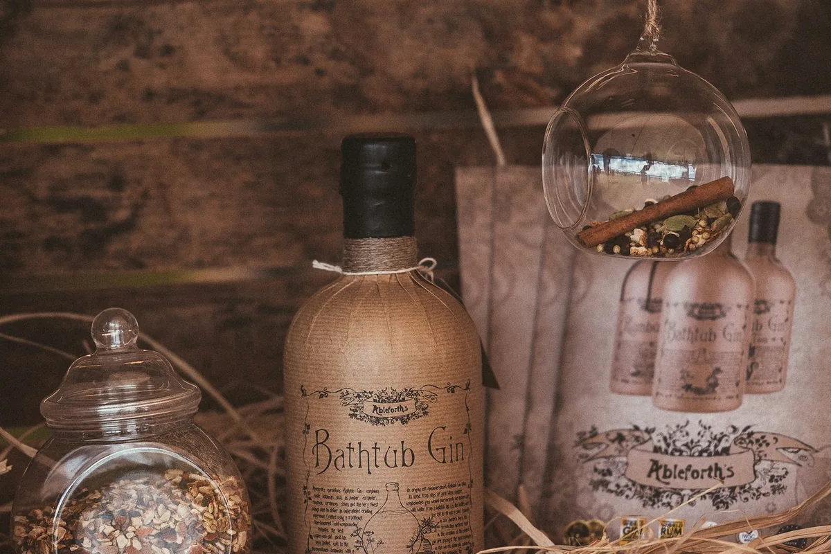 Gin bottles displayed with botanicals and glassware