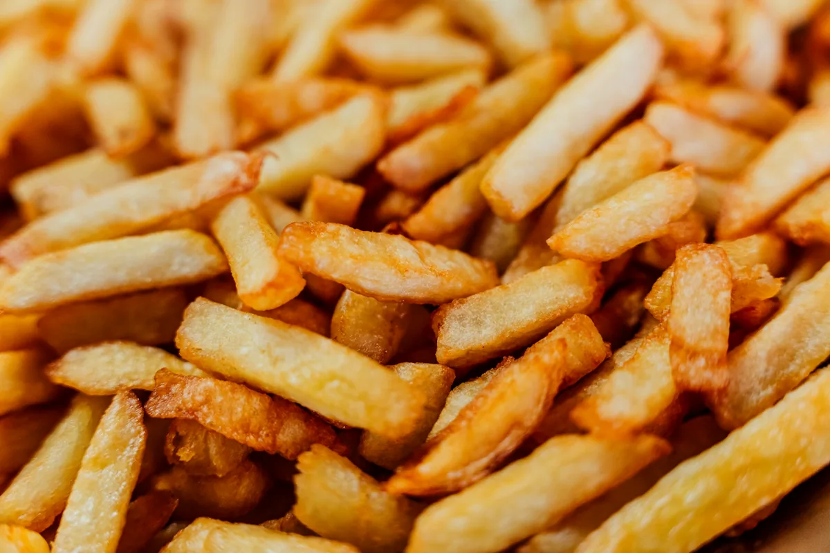 A close-up pile of thick golden fries