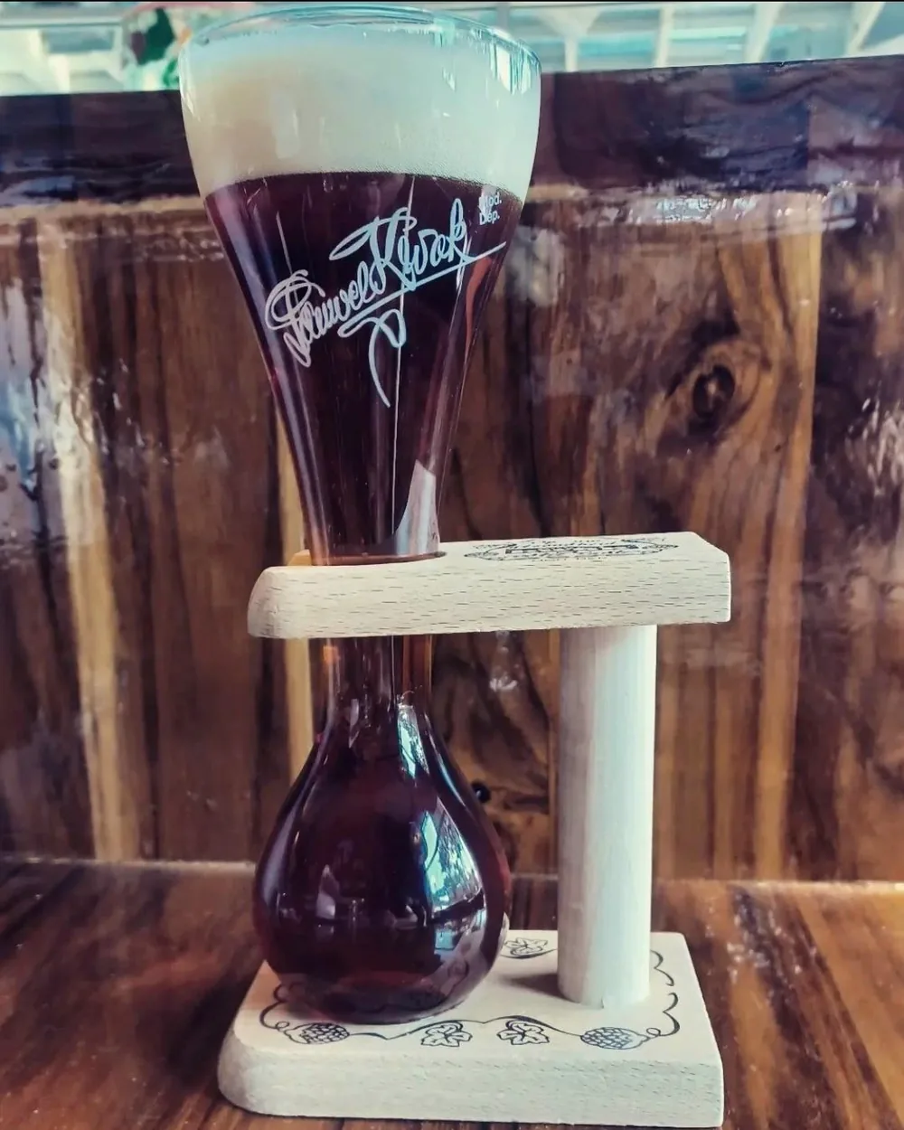 A Kwak beer in its rounded glass, held upright in a turned wooden stand