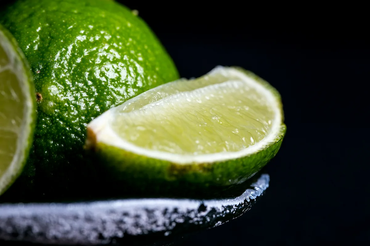 A wedge of lime resting on the salted rim of a cocktail glass