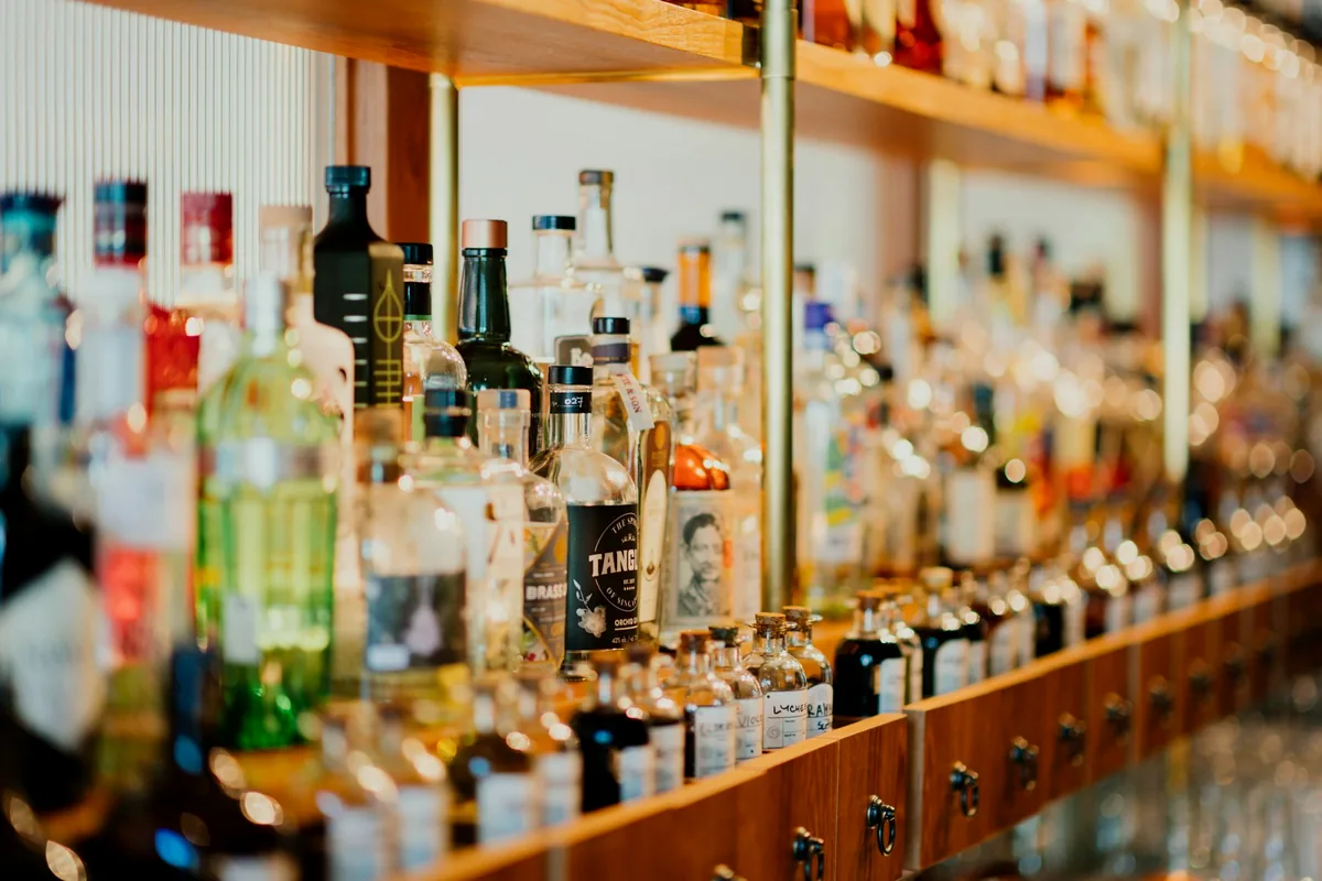 Close-up of liquor bottles held in a wooden rack
