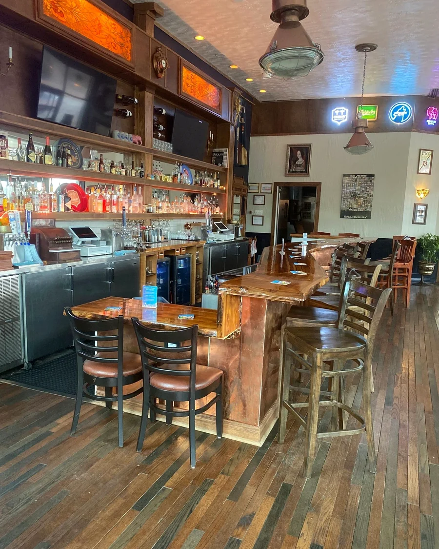 The wooden bar and stools at Meyboom Brasserie with tables beyond
