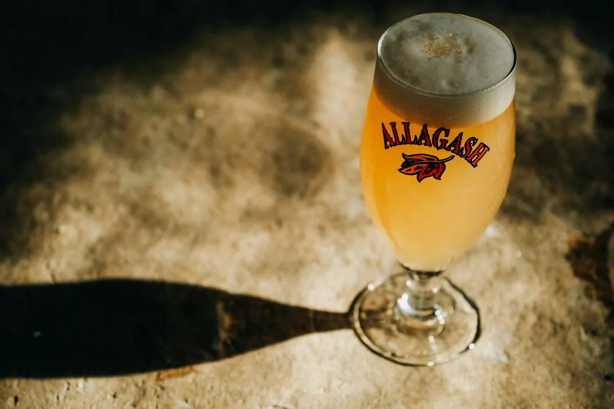 A pale golden ale with a thick head in a stemmed glass
