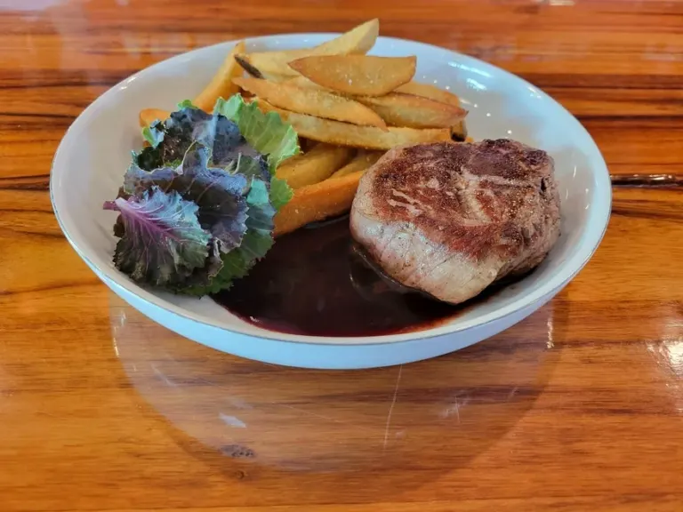 A filet of beef in bordelaise sauce with frites and dressed leaves