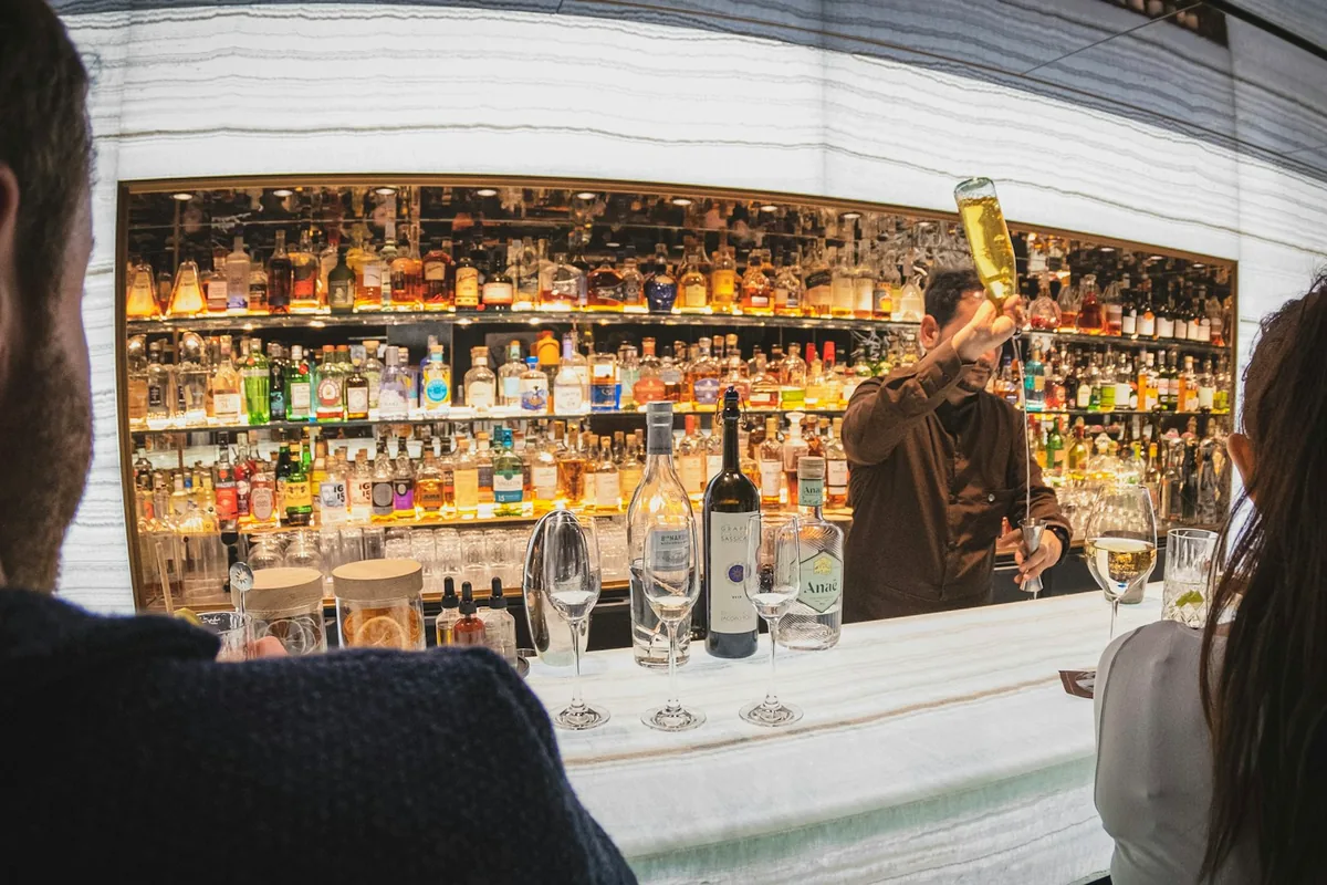A bartender pouring a drink behind a bar