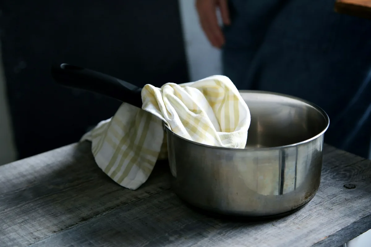 A saucepan with a folded cloth over the handle