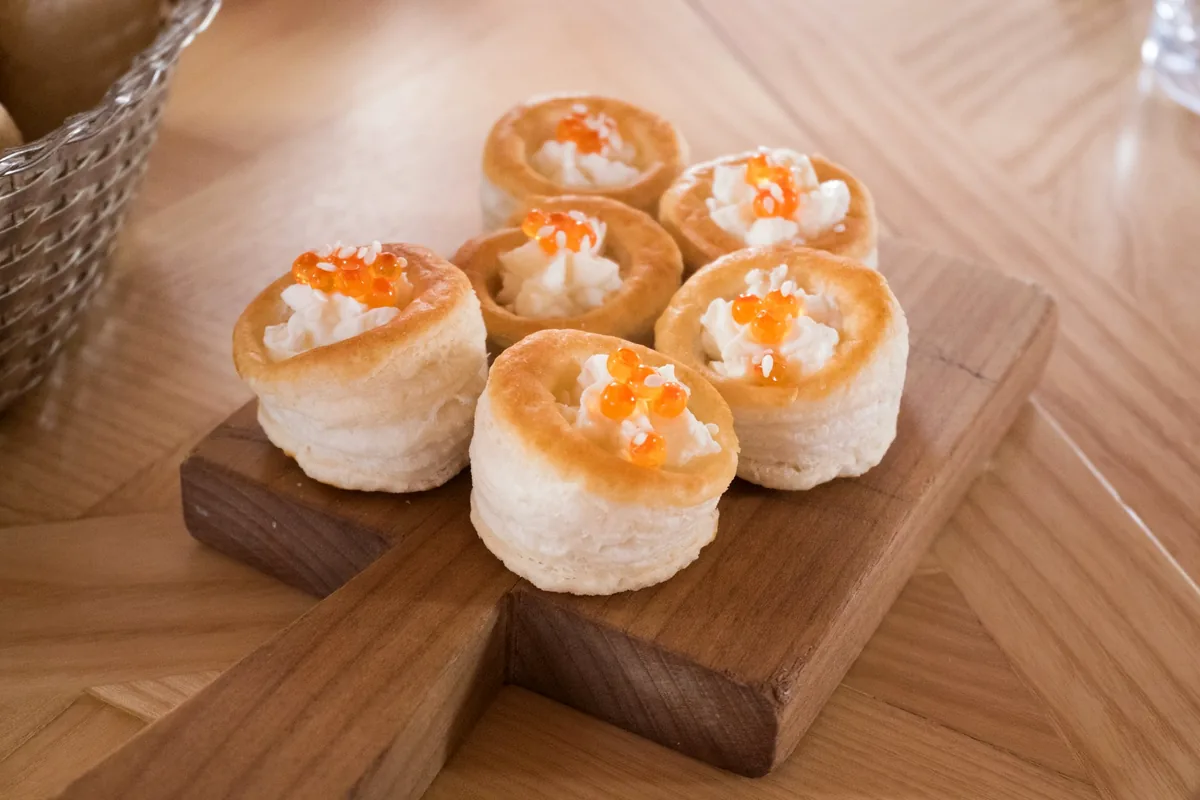 Six small puff pastry cases filled with cream and topped with roe
