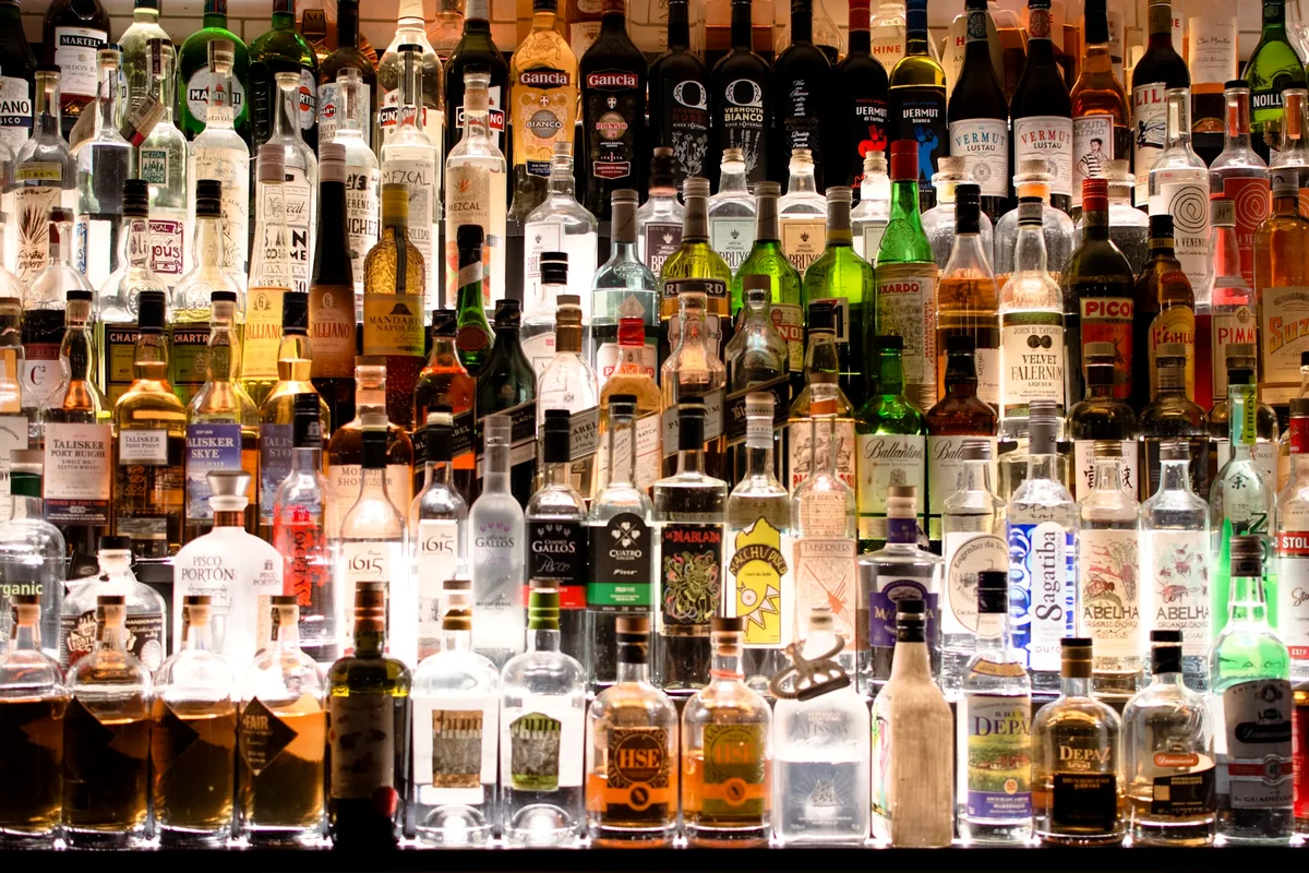 A wall of assorted spirit and liqueur bottles behind a bar