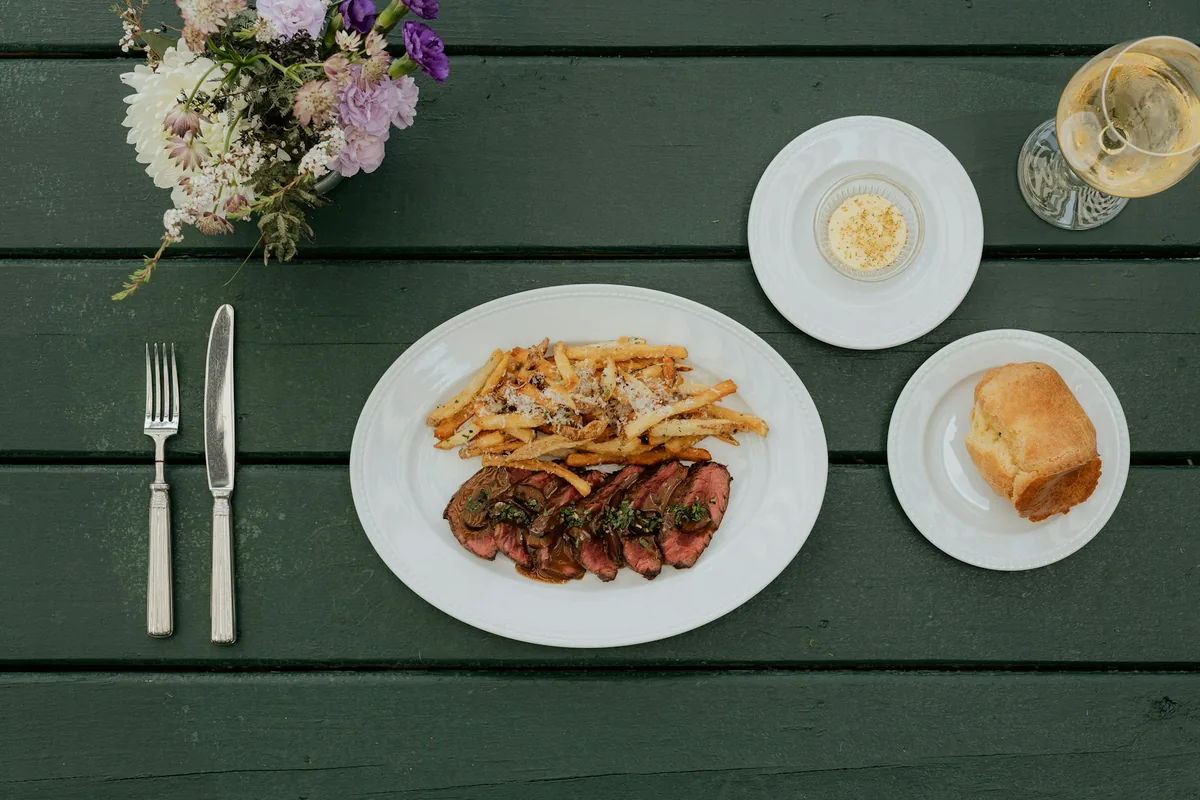A plate of sliced steak with french fries