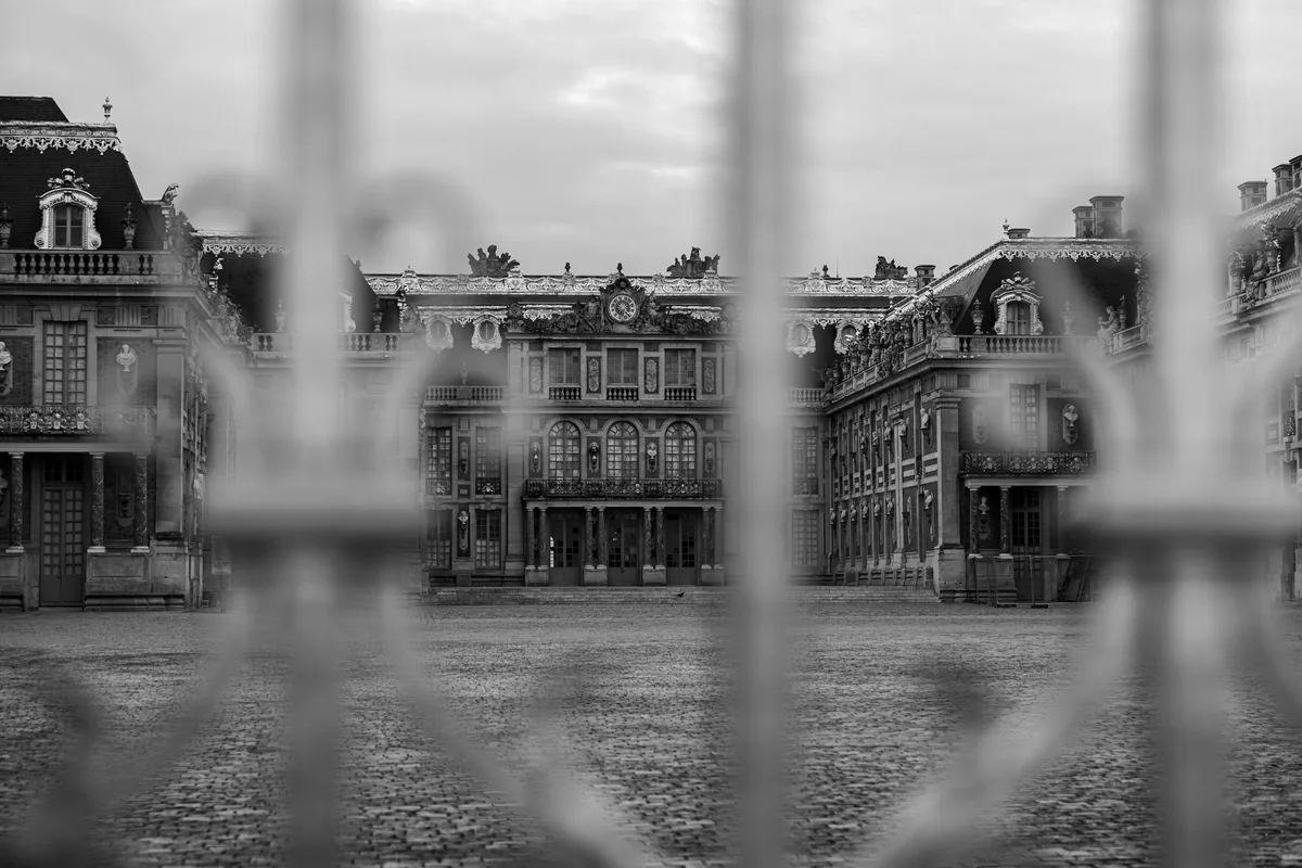 The front of the Chateau de Versailles seen through railings