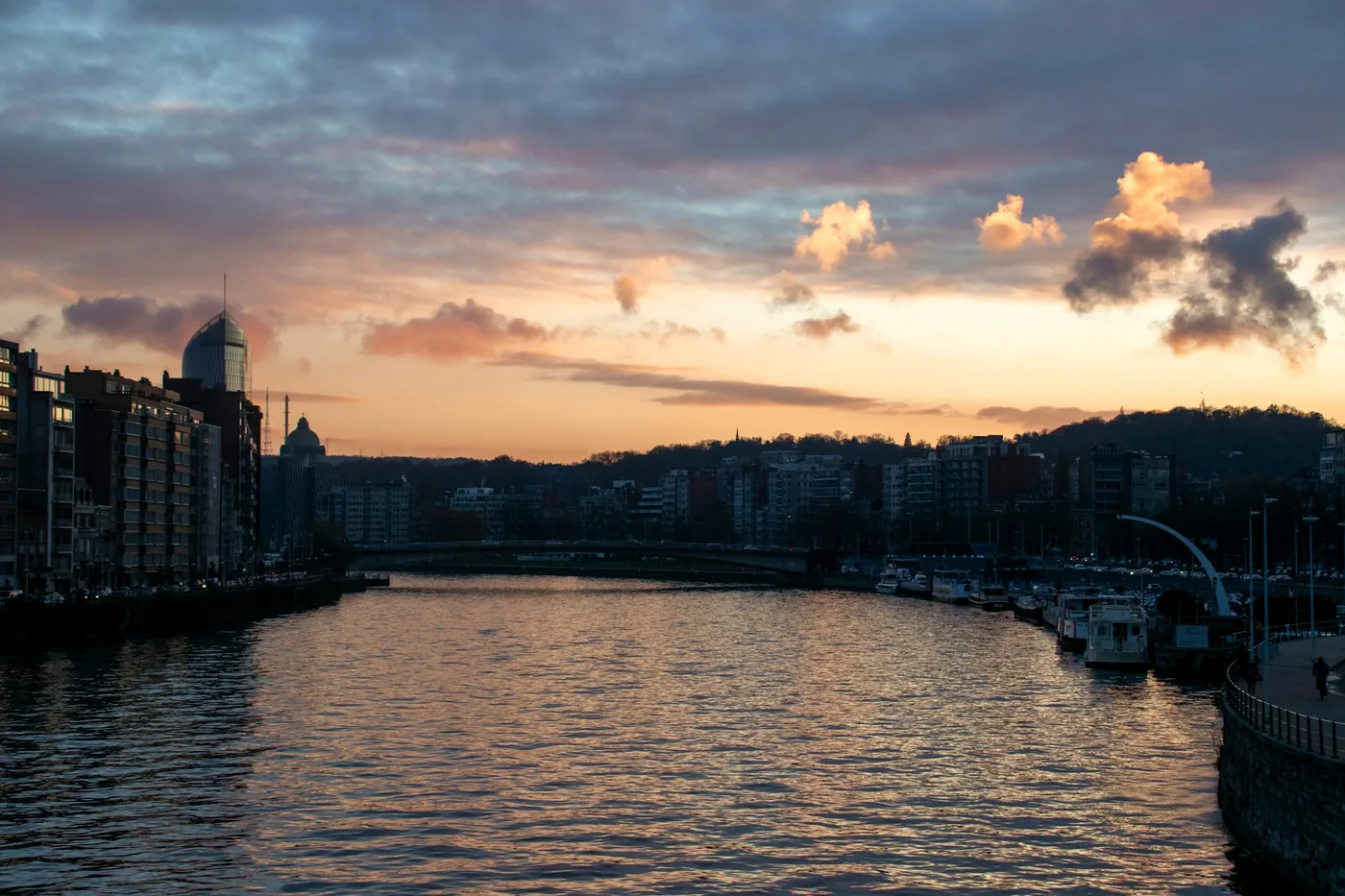 The Meuse river running through Liege at sunset with bridges and quays
